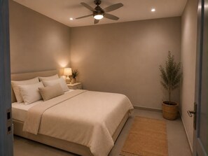 Ein Schlafzimmer mit Bett, Nachttisch, Lampe, Deckenventilator und einer Zimmerpflanze.