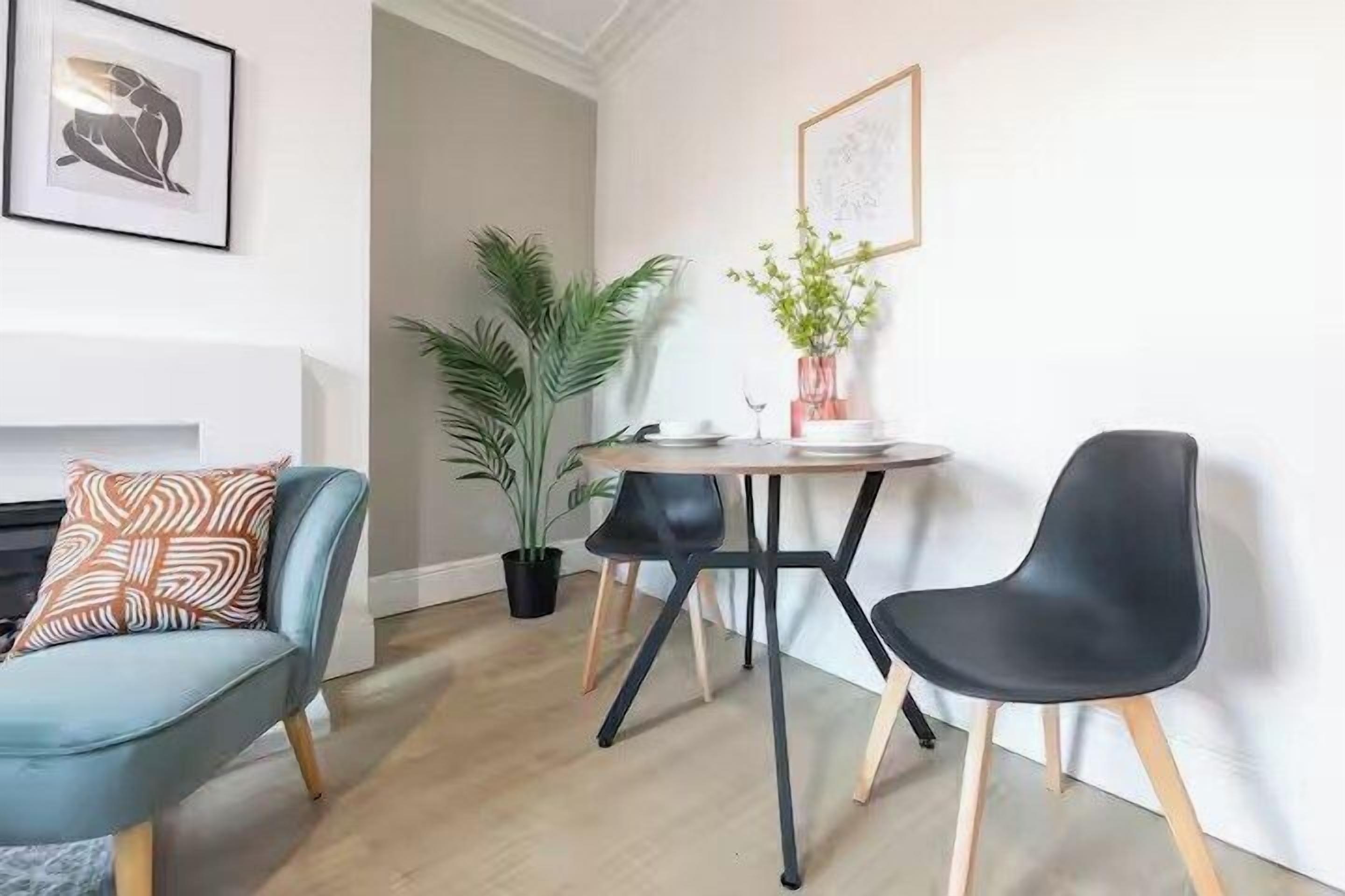 Een moderne woonkamer met een bank, twee stoelen, een salontafel en een open haard.