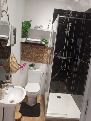 Ein modernes Badezimmer mit Toilette, Waschbecken und einer Duschkabine.