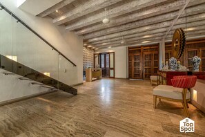 A spacious interior with a wooden floor, a glass staircase, and a dining area with traditional decor. - TopSpot® Duplex PH @ The Historic Center Heart (Cartagena de Indias)