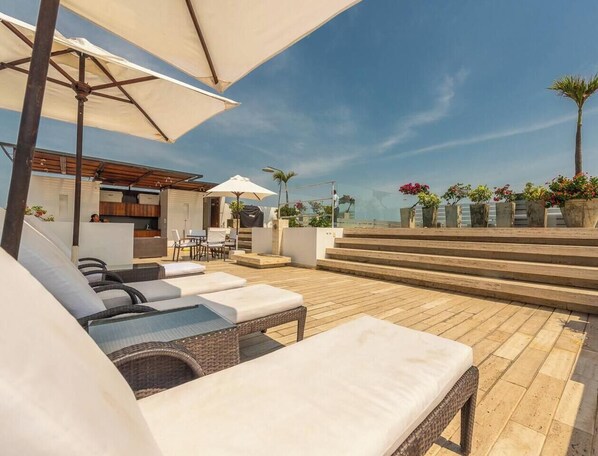 A rooftop terrace with lounge chairs, a bar area, and a view of the sea. - TopSpot® Duplex PH @ The Historic Center Heart (Cartagena de Indias)
