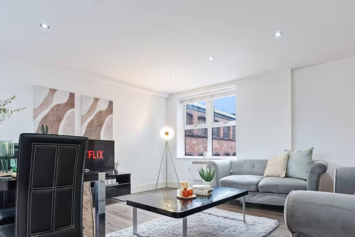 Un salon moderne comprenant un canapé, une table basse, un téléviseur et une lampe sur pied.