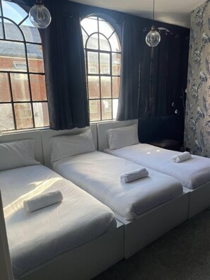 A room with a large bed, a window with curtains, and a hanging light fixture. - #84 Large JQ apartment sleeps 9 (West Midlands)