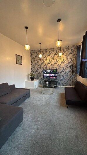 A living room with a sofa set, a coffee table, and a television. - #84 Large JQ apartment sleeps 9 (West Midlands)
