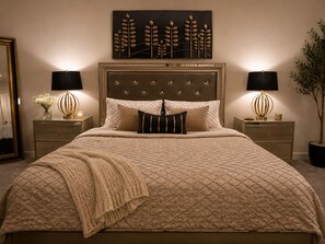 A bedroom with a large bed, two bedside tables, a headboard, and a wall-mounted artwork. - Spacious studio by the woods (Laurel)