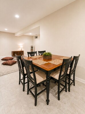 A dining area with a wooden table, black chairs, and a small plant centerpiece. - Spacious studio by the woods (Laurel)