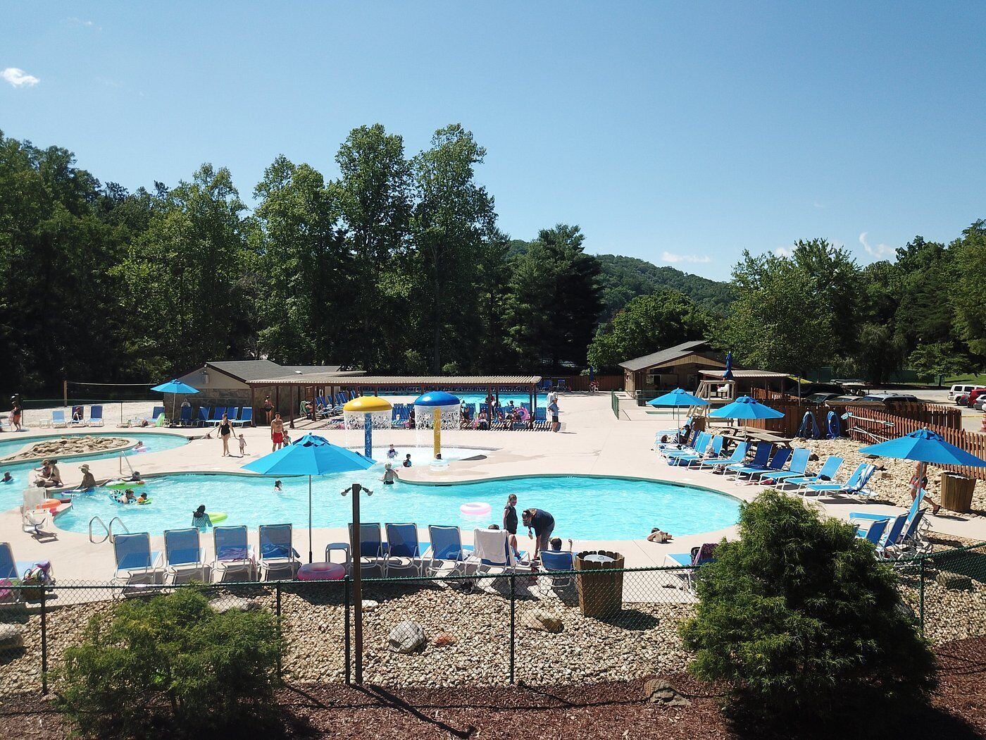 Uma área de piscina com várias piscinas, espreguiçadeiras e guarda-sóis.