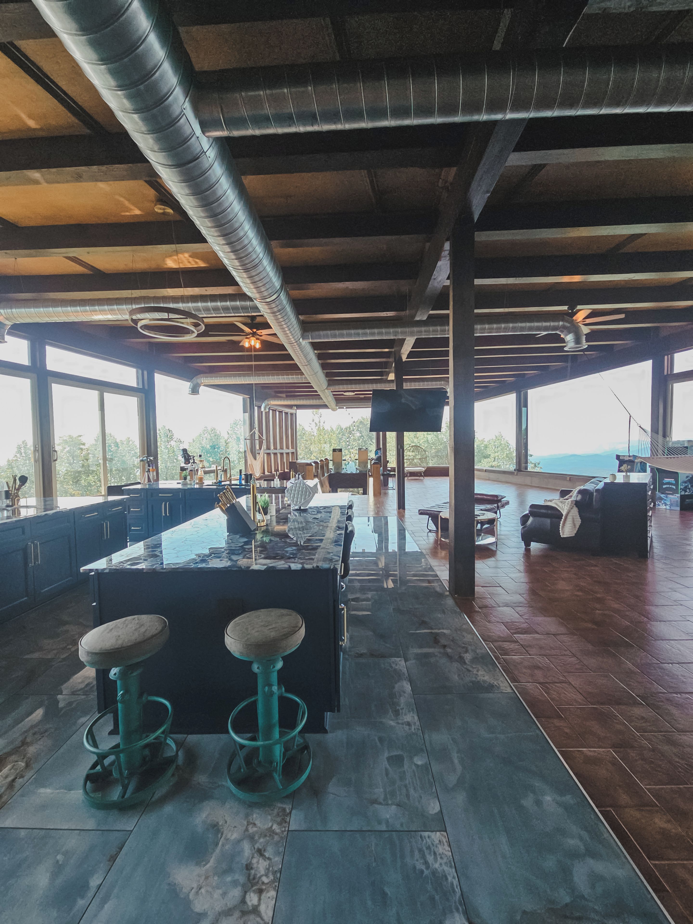 Un espacio interior amplio con una barra grande, asientos y vistas amplias a través de ventanas.