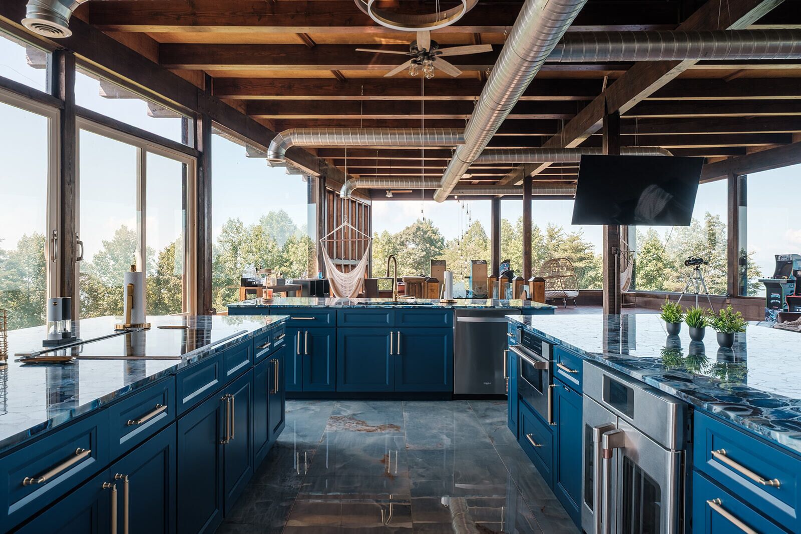 A modern kitchen with blue cabinets, stainless steel appliances, and a large island.