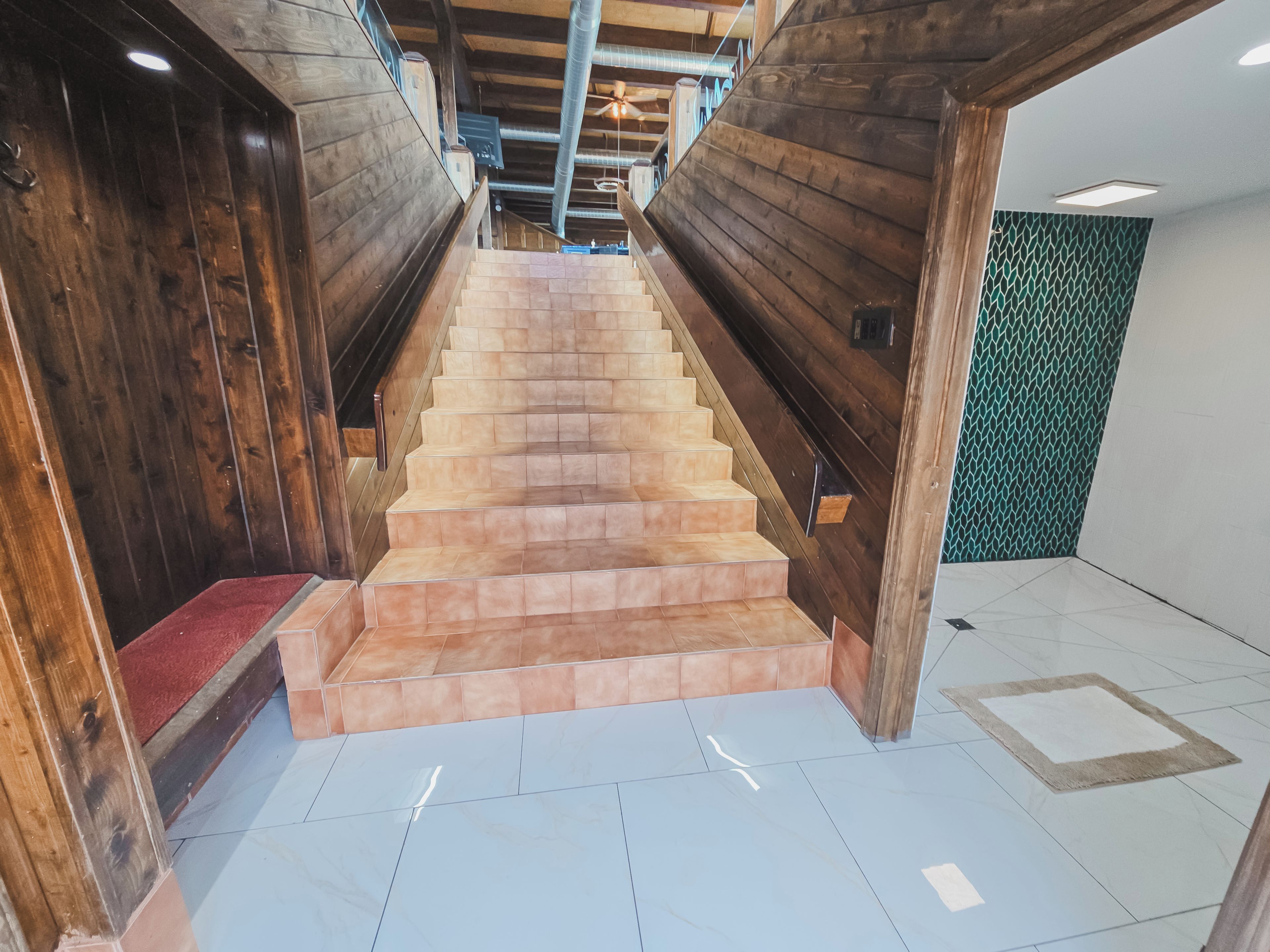 A staircase with wooden handrails and beige steps leading to an upper floor.