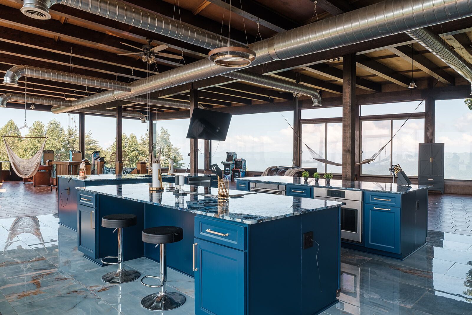 Una cocina amplia con una isla grande, taburetes de bar y vistas al exterior.