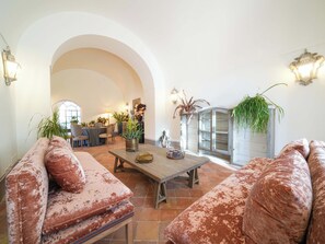 A spacious living room with a high arched doorway, a wooden coffee table, and two sofas with a distressed finish. - Luxury Estate with Private Pool and Panoramic Sea Views (Sorrento)