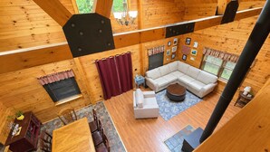 A spacious cabin with a large living area, a dining table, and a cozy seating arrangement. - Serene 4-bedroom house in the beautiful White Mountains. (Haverhill)