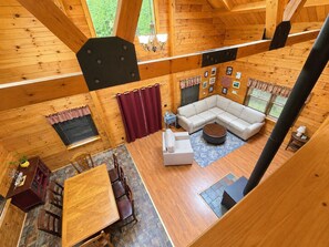 A spacious cabin with a large living area, a dining table, and a cozy seating arrangement. - Serene 4-bedroom house in the beautiful White Mountains. (Haverhill)