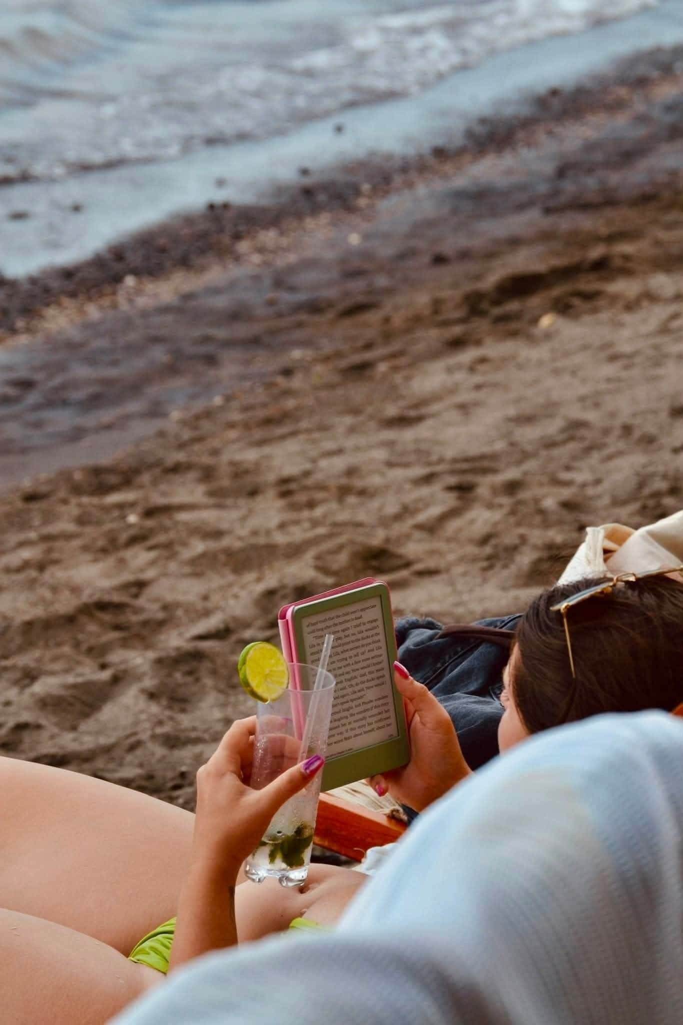 A person reading a book at the beach.