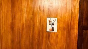 Una habitación con pared de madera, una mesita y una puerta.