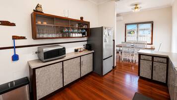 A modern kitchen with a microwave, refrigerator, and wooden cabinets.