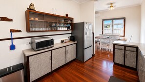 Cocina moderna con microondas, refrigerador y armarios de madera.