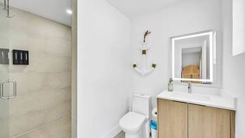 Une salle de bain moderne équipée de toilettes, d’un lavabo et d’une zone douche.