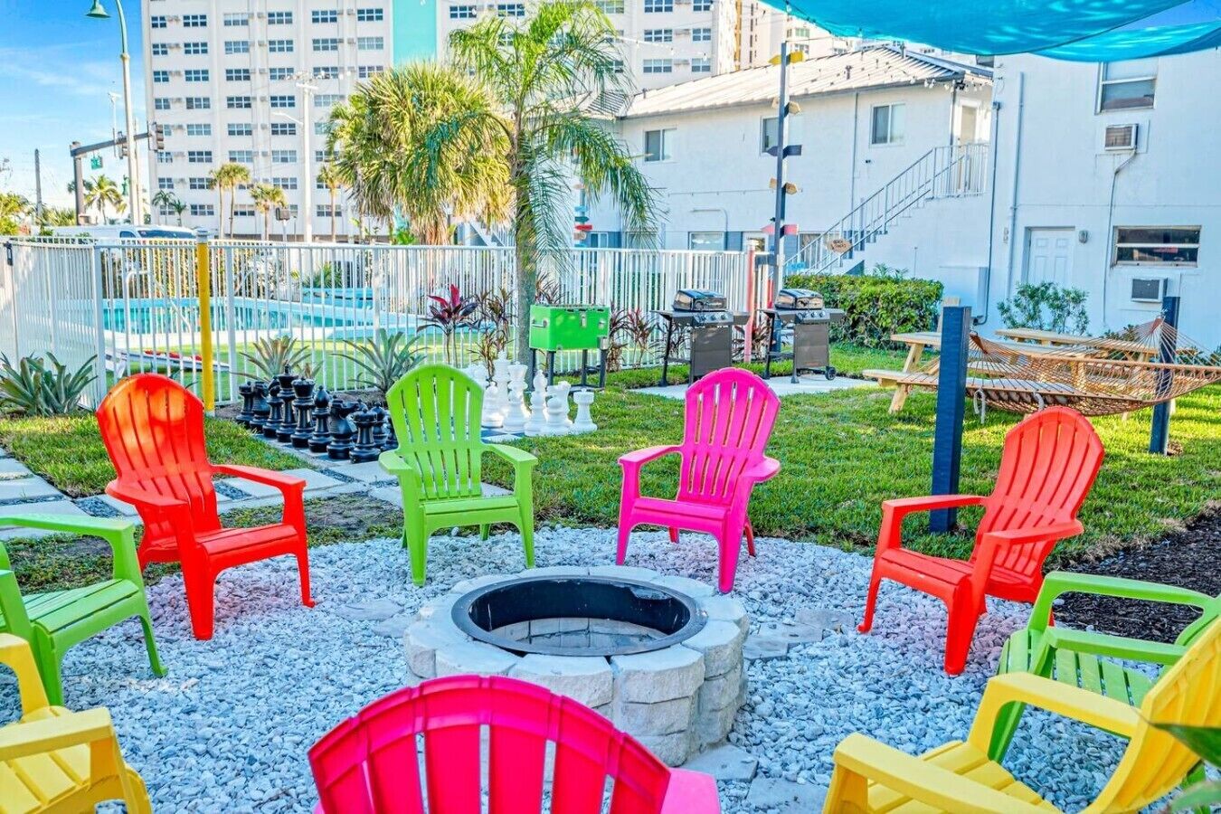 A patio area with outdoor seating, a fire pit, and a view of a residential building.