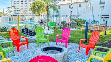 A patio area with outdoor seating, a fire pit, and a view of a residential building.