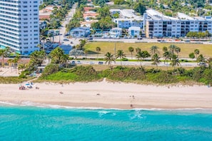 Una zona costera amb una platja, un aparcament i edificis d'estil arquitectònic modern.
