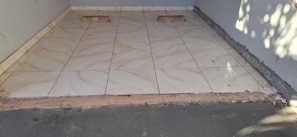 A tiled floor with a visible crack and a small gap at the bottom.