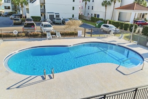 A swimming pool with a clear blue water, surrounded by a fence, and adjacent to a parking area with several cars. - Steps to the Private Beach, renovated, 2 Bikes - Time to Coast (Santa Rosa Beach)