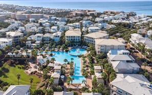 A resort with multiple buildings, a central swimming pool, and a view of the ocean. - Pirate's Smile (Panama City Beach)
