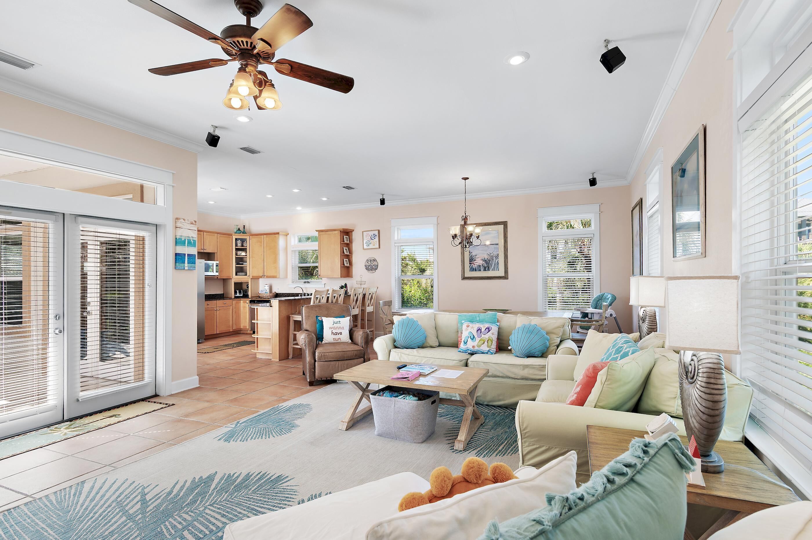 A spacious living room with a sofa, coffee table, and a ceiling fan.
