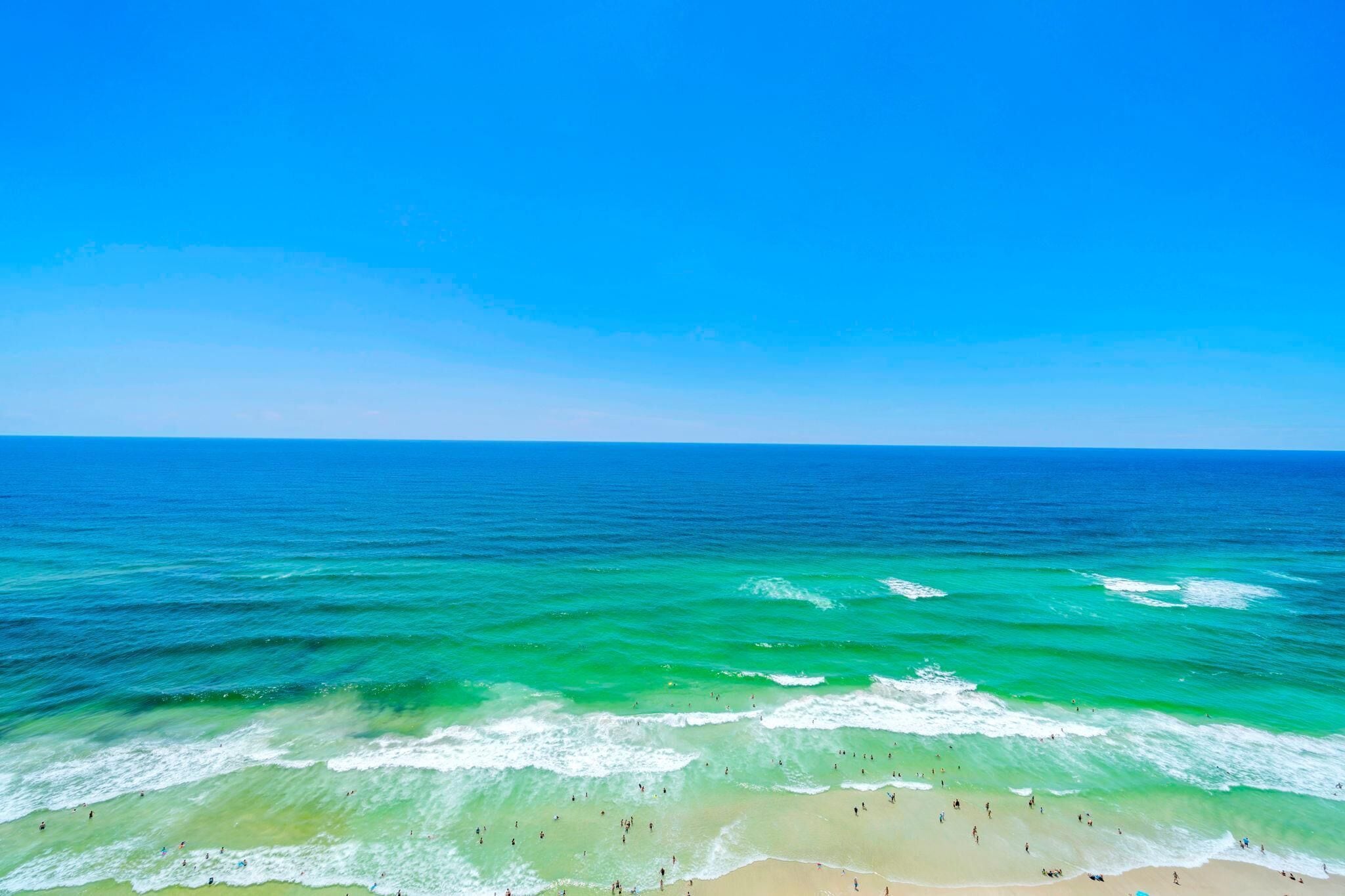 Una playa con aguas turquesas cristalinas y una orilla arenosa.
