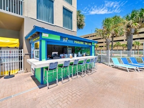 A tiki bar with outdoor seating and a poolside view. - Tidewater 2112 (Panama City Beach)