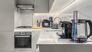 Une cuisine moderne équipée d’un four encastré, d’une machine à café et d’un grille-pain.