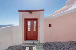 A red door with a white wall and a small window to the right. - The San Villa with Caldera Sea View and Private Hot Tub in Oia (Oia)
