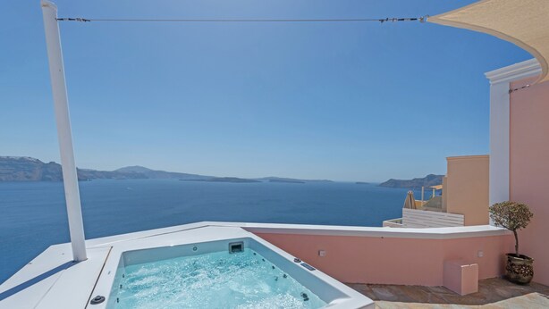 Uma banheira de hidromassagem numa varanda com vista para o mar.