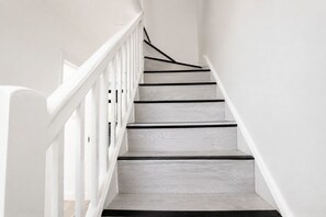 A staircase with white railings and grey steps.