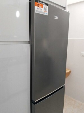 Un refrigerador de dos puertas con una etiqueta llamativa que dice 'Importante' y el logotipo de 'beko'.