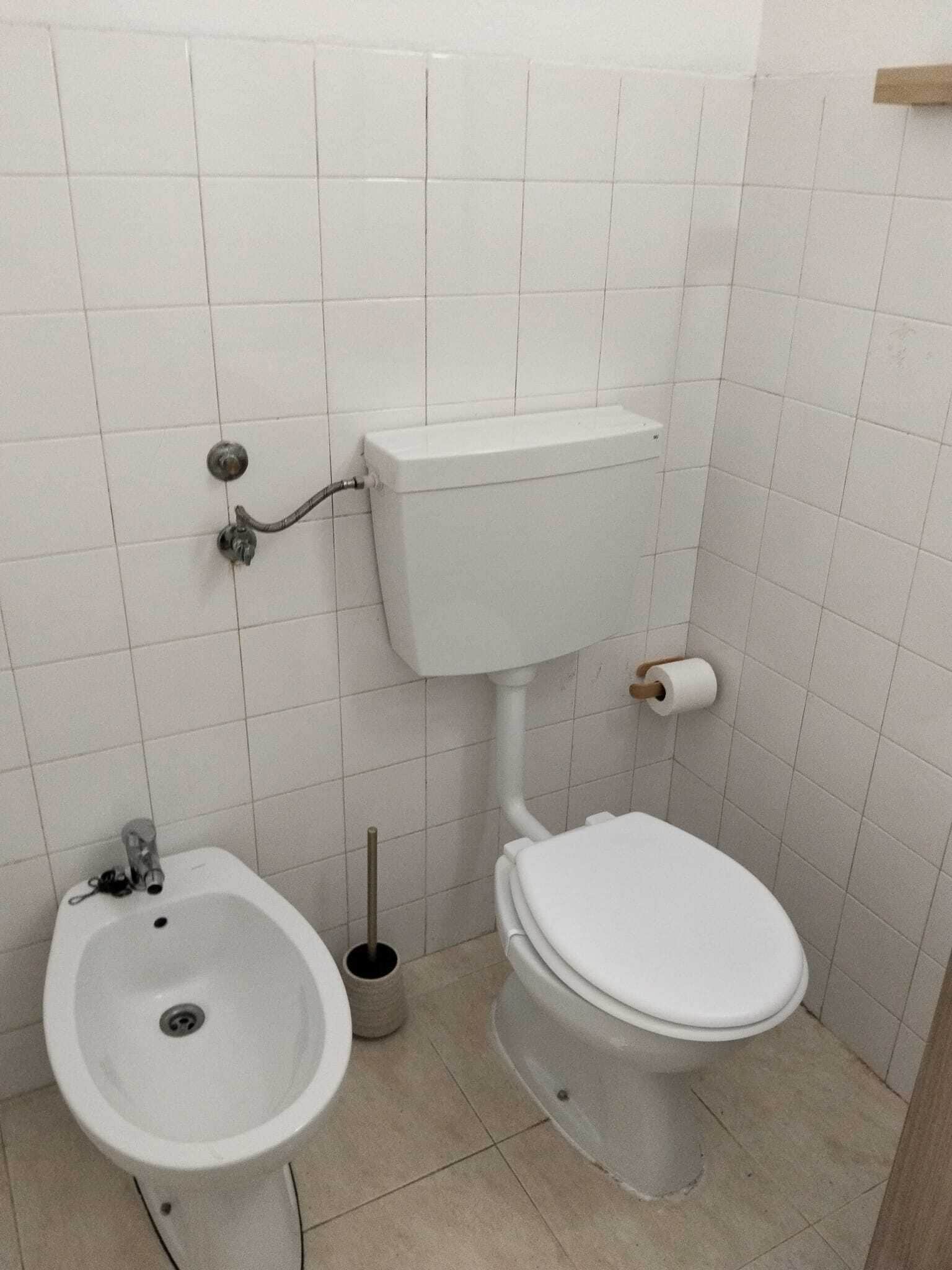 Un baño pequeño con inodoro, bidé y lavabo.