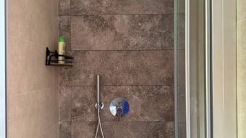 Eine Dusche mit Duschkopf und Brausehandstück.