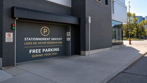 En bygning med en garageport, der viser et skilt med gratis parkering under opholdet.