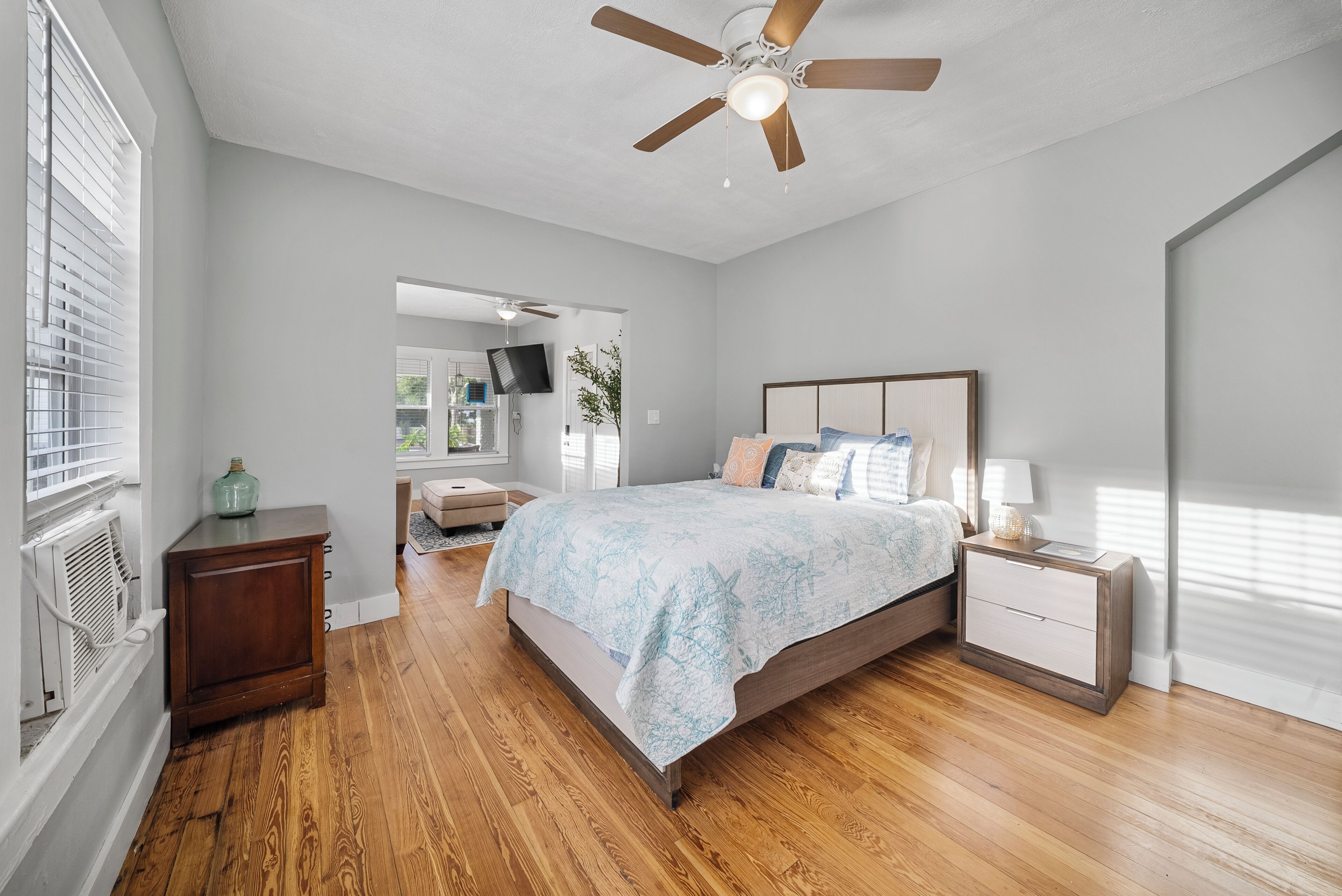 A bedroom with a bed, nightstand, and a ceiling fan.