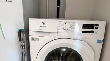 Máquina de lavar frontal com painel de controle, um código QR e uma etiqueta indicando que é o modelo 600 SENSICARE 10kg.