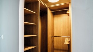 A walk-in closet with wooden shelving and a hanging rod.