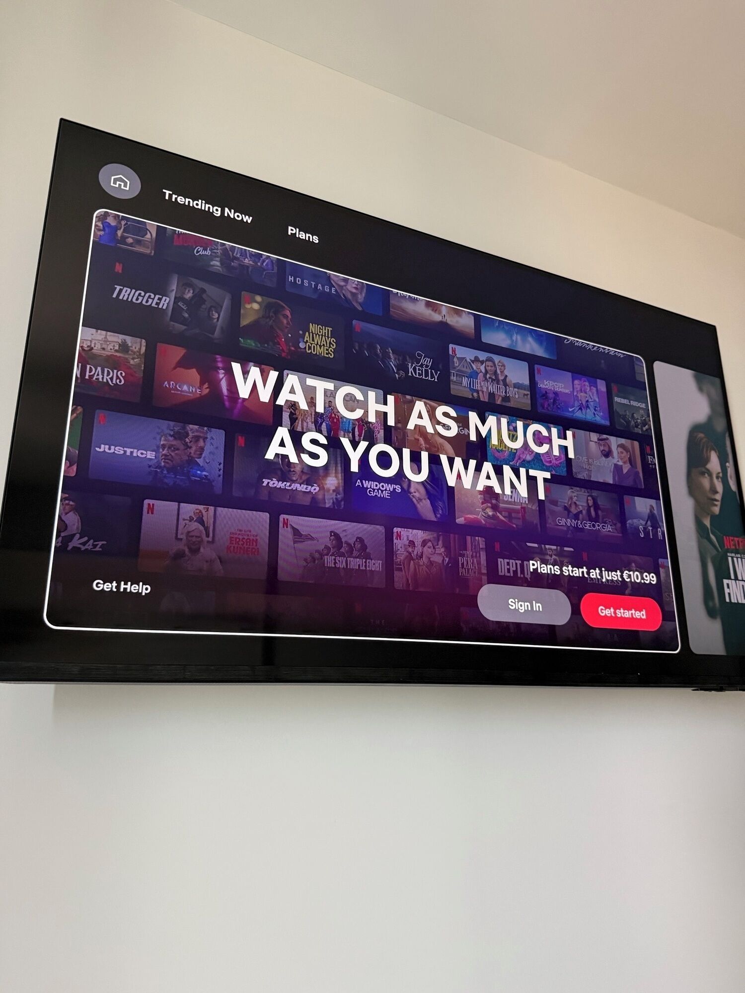 A television displaying a streaming service interface with a prominent 'WATCH AS MUCH AS YOU WANT' message.