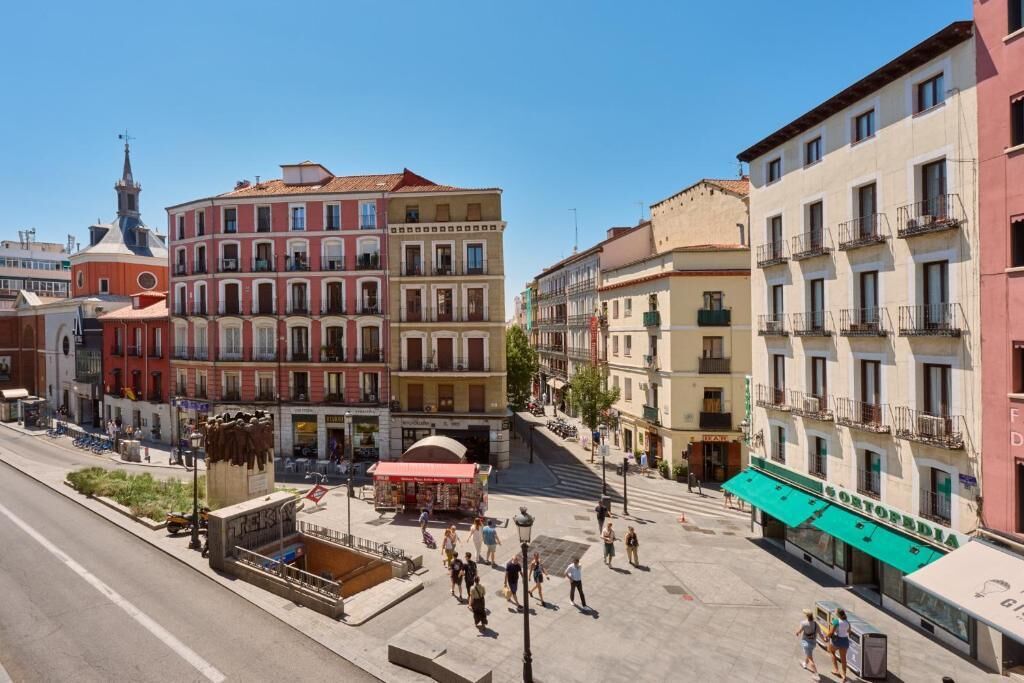 Una plaza con edificios, una fuente y una calle.