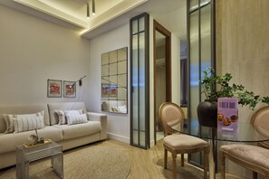 Una sala de estar moderna con sofá, sillones, una mesa de centro y un separador de vidrio.