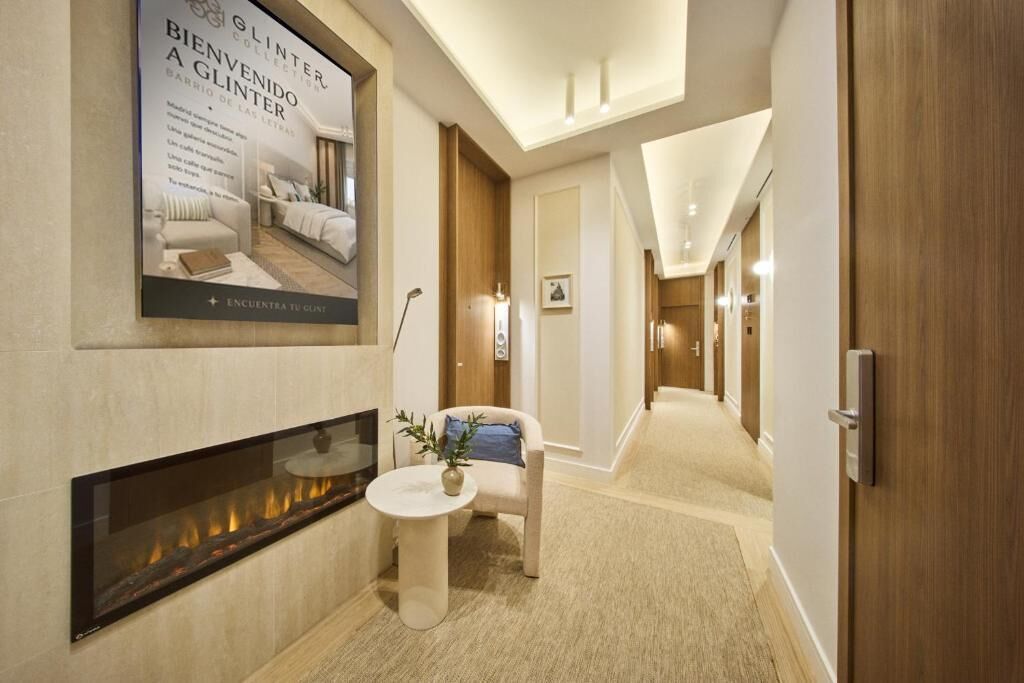 A hotel lobby with a fireplace, a sofa, and a poster on the wall.