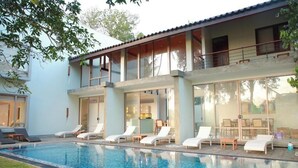 A modern two-story house with a swimming pool, outdoor seating, and large windows. - ONA Garden Villa: Deluxe Suite (Galle)