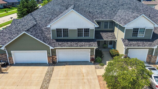 A two-story residential house with a garage, a driveway, and a well-maintained lawn.
