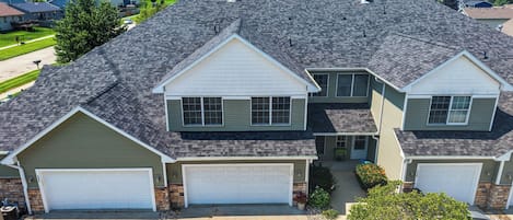 A two-story residential house with a garage, a driveway, and a well-maintained lawn.